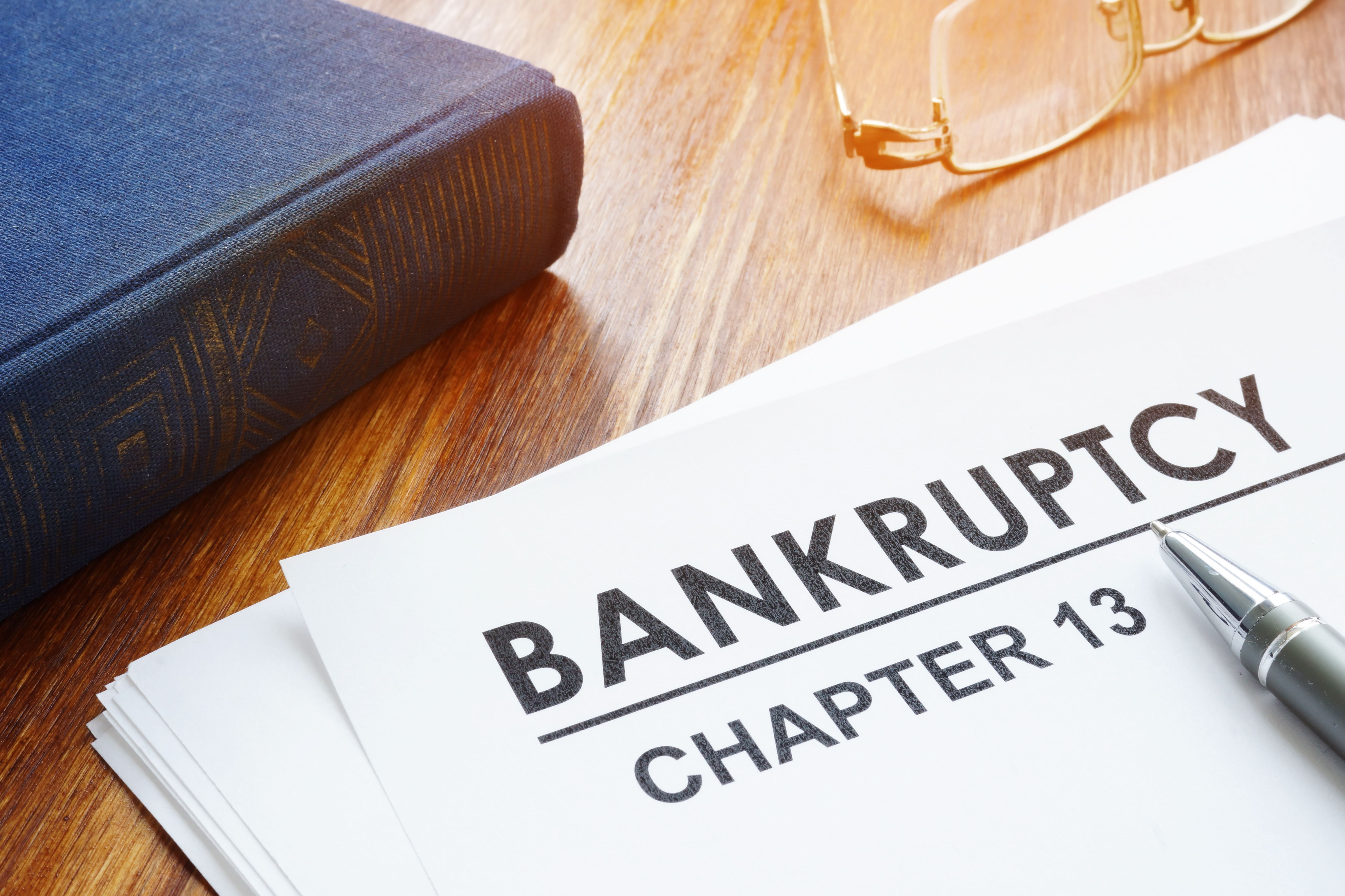 bankruptcy chapter 13 paperwork sitting atop wooden desk